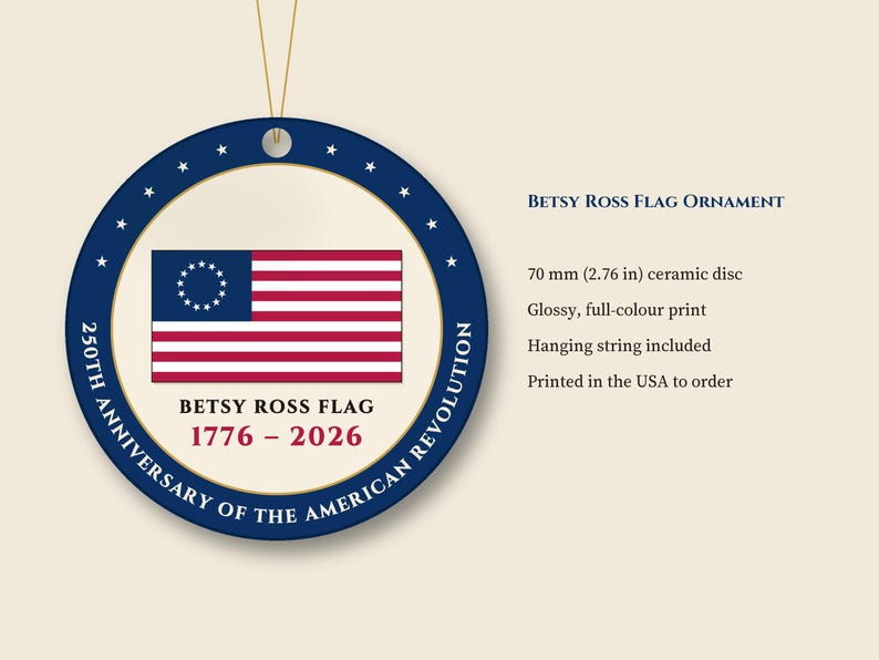 May include: A round 70 mm ceramic disc ornament featuring the Betsy Ross flag with 13 stars in a circle. The blue border displays the text 250TH ANNIVERSARY OF THE AMERICAN REVOLUTION. Below the flag, the text reads BETSY ROSS FLAG 1776 - 2026.