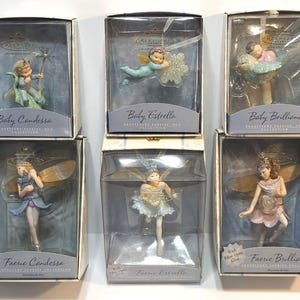 May include: Six Hallmark Keepsake ornaments in individual boxes. Top row: Baby Candessa with a star wand, Baby Estrella with a snowflake, and Baby Brilliana. Bottom row: Faerie Candessa, Faerie Estrella, and Faerie Brilliana with fiber-optic glow.