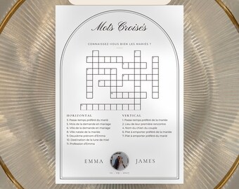 May include: A white wedding crossword puzzle card with black text and an arched border. The card features the title Mots Croisés, horizontal and vertical clues, and the names Emma and James with a small circular photo and the date 12.09.2027.