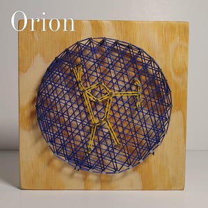 May include: A square wooden board features a circular string art design with the word Orion printed in the top left corner. The design uses blue string to create a dense background web and yellow string to form a constellation shape.