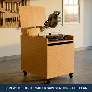 May include: A light brown wooden flip-top miter saw station on black caster wheels. The unit features a vertical back panel and a flat surface holding a gray miter saw. The text 38 IN WIDE FLIP-TOP MITER SAW STATION - PDF PLAN is visible.