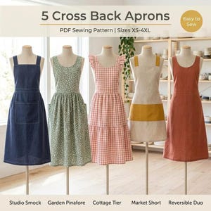 May include: Five cross back aprons displayed on mannequins, featuring a PDF sewing pattern for sizes XS-4XL. The styles include a navy blue studio smock, a green floral garden pinafore, a pink gingham cottage tier, a mustard and beige market short, and a solid rust reversible duo.