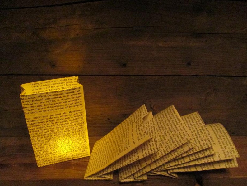 May include: A yellow paper bag lantern with text printed on it, lit from the inside. The text reads "treating all subjects in a similar tone of a walk but nowhere extraordinarily pretty, I have never been so much impressed. That this extraordinary..."