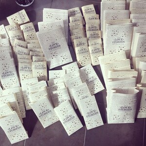 May include: A pile of folded paperbacks with the text "Read Love Stories" printed on the covers. The covers are decorated with small hearts.