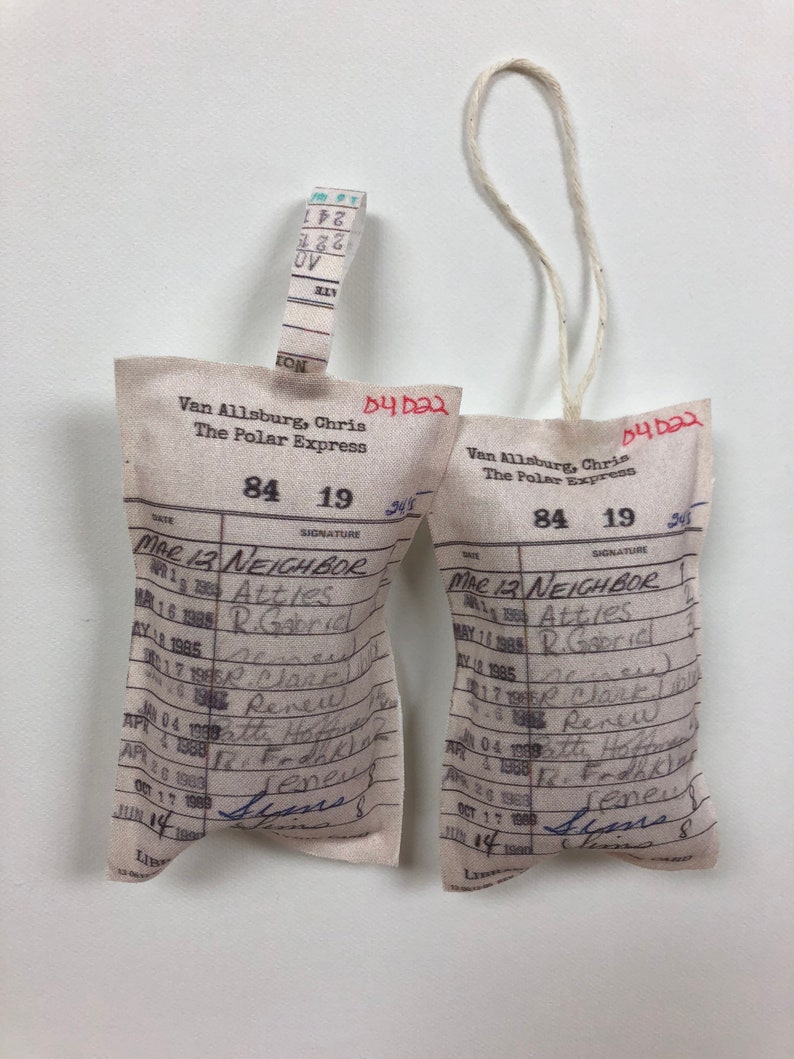 May include: Two white fabric tags with a red string attached. The tags are labeled "The Polar Express" and have a date of "84 19". The tags have a list of dates and signatures.