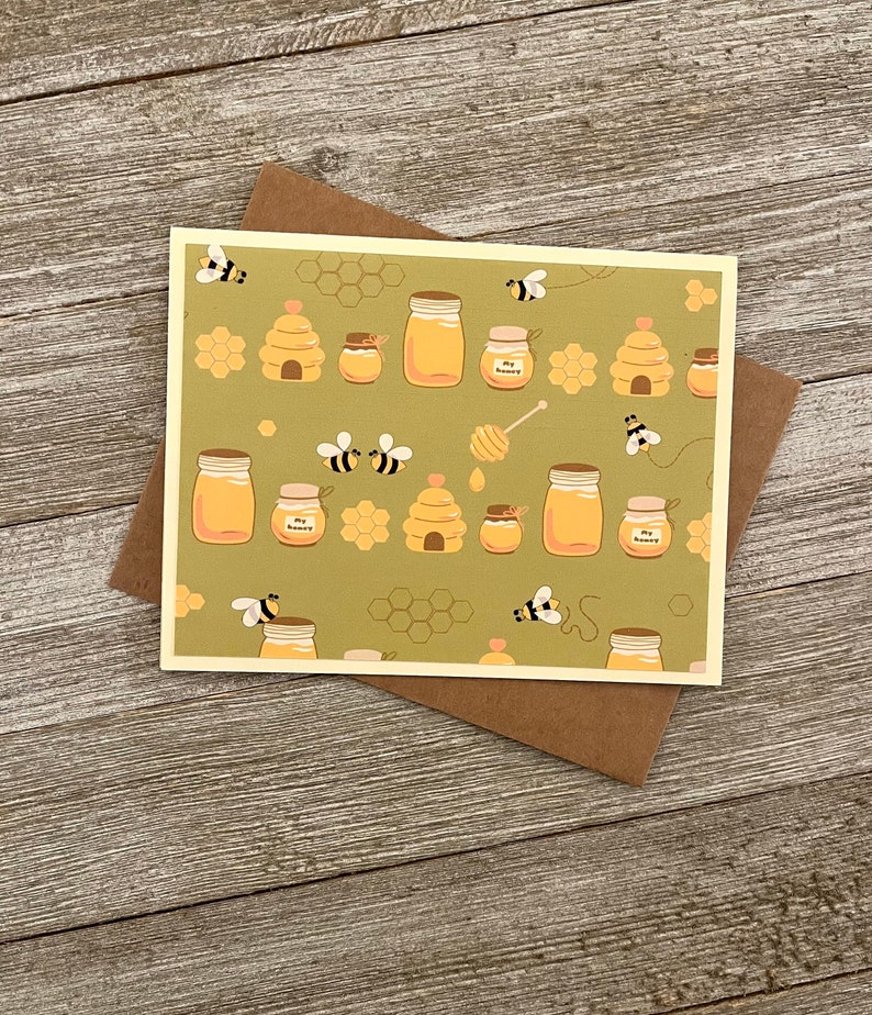 Puede incluir: Una tarjeta verde con un patr&oacute;n de tarros de miel, panales y abejas. El texto en los tarros dice "My Honey".