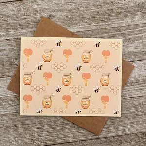 Puede incluir: Una tarjeta de color amarillo claro con un patr&oacute;n repetido de tarros de miel, panales, corazones y abejas. Los tarros de miel est&aacute;n etiquetados con "My Honey".