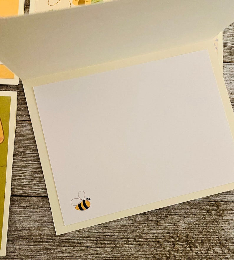 Puede incluir: Tarjeta de felicitaci&oacute;n en blanco con una ilustraci&oacute;n de abeja amarilla y negra en el interior.