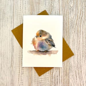 May include: A watercolor painting of a small, fluffy bird with brown, blue, and orange feathers. The bird is perched on a branch and is looking to the side.