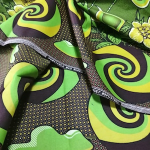 May include: Green and brown fabric with a swirling pattern and yellow flowers. The fabric has the text "VERITABLE WAX BLOCK" and "TARGET 89PC97801" printed on it.