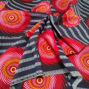 以下が含まれることがあります： 紺色と白のストライプの生地に、赤、ピンク、黄色の渦巻き模様が描かれています。生地の端には「ORIGINAL JAVA BLOCK PR QUAL」という文字が印刷されています。