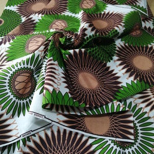 May include: White fabric with a repeating pattern of brown and green stylised flowers. The fabric has a brown and white label with the text "GND VENICE" and "851405".