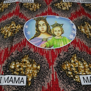 May include: A colorful fabric with a repeating pattern of black, red, and gold. The fabric features a circular image of a woman and child in a blue circle with white stars. The text "MAMA NI MAMA" is repeated on the fabric.