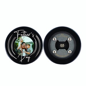 Peut inclure: Ouvre-bouteille en forme de rondelle de hockey noir avec un insert photo et le texte "Father's Day" en &eacute;criture blanche. Le dos de la rondelle porte le texte "The Puck Opener" et "BuffaloBottleCraft.com" en or.