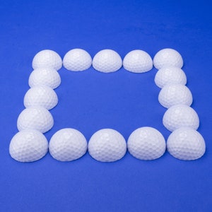 May include: A square frame made of white golf balls on a blue background.