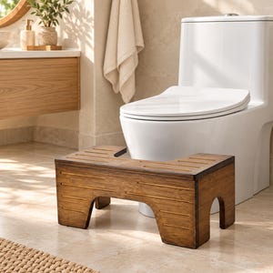 May include: A dark brown wooden toilet stool featuring a U-shaped cutout design, horizontal slats on the top surface, and four sturdy legs. The stool has a natural wood grain finish and is positioned directly in front of a white toilet.