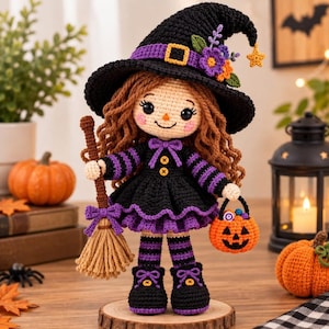 Pode incluir: Uma boneca de crochê vestida de bruxa, com longos cabelos castanhos, um chapéu preto com detalhes roxos e flores, e um vestido listrado de preto e roxo. A boneca segura uma vassoura bege e uma pequena cesta laranja em forma de abóbora.