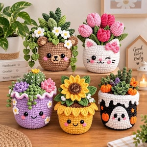 May include: Five crocheted plant pots with faces. One is a brown bear with succulents, one a white cat with pink tulips, one a purple pot with a cactus and flowers, one a yellow sunflower pot, and one a black pot with a ghost and pumpkins.