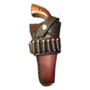 May include: A brown leather holster with a black leather ammo loop. The holster is designed to hold a small revolver with a wooden handle. The ammo loop holds six rounds of ammunition.