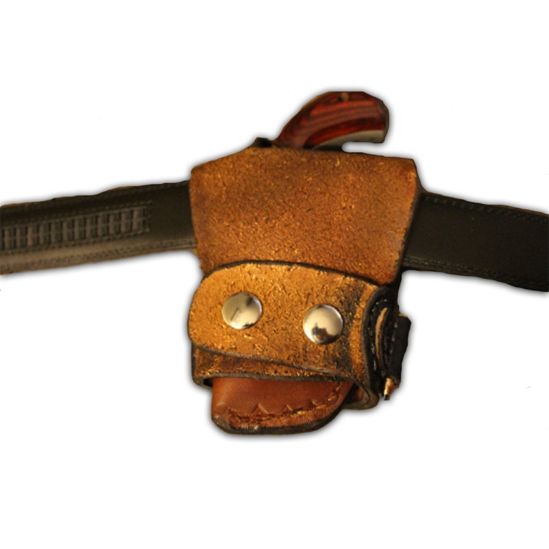 K&ouml;nnte beinhalten: Ein braunes Lederholster mit goldener Oberfl&auml;che und zwei silbernen Druckkn&ouml;pfen. Das Holster ist f&uuml;r ein kleines Taschenmesser oder ein anderes kleines Werkzeug konzipiert.