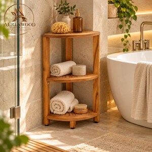 May include: A three-tier wooden corner shelf with a natural finish. The top shelf holds a yellow sponge and a brown pump bottle. The middle shelf holds a rolled white towel and a round container. The bottom shelf holds two rolled white towels and a wooden brush.