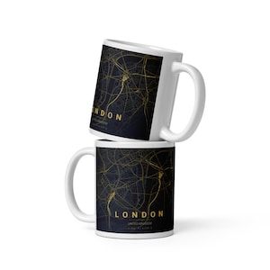 May include: Two white ceramic mugs stacked vertically, each featuring a dark navy blue background with a detailed gold street map of London, United Kingdom. The text LONDON is printed in gold capital letters at the bottom of the map design.