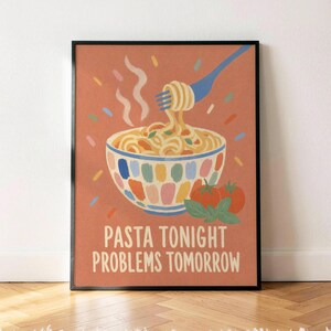 May include: A framed wall art print with a terracotta background featuring a bowl of pasta, a blue fork lifting noodles, two red tomatoes, and green basil leaves. The text reads PASTA TONIGHT PROBLEMS TOMORROW in a cream-colored sans-serif font.