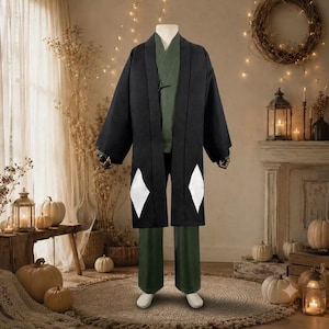 Puede incluir: Una chaqueta haori negra con patrones en forma de diamante blanco en los paneles frontales inferiores, usada sobre una parte superior estilo kimono de color verde oliva sólido y pantalones verde oliva a juego, sobre un maniquí.
