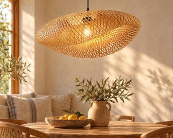 May include: A large, oval-shaped pendant light fixture crafted from woven light brown bamboo strips. The shade features an intricate, crisscross lattice pattern that allows a warm, glowing light to diffuse through the gaps, suspended by a black cord.