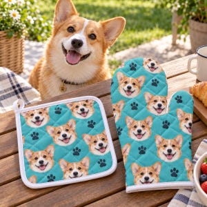 May include: A quilted oven mitt and a square pot holder in a teal color, both featuring a repeating pattern of Corgi dog faces and dark blue paw prints. The fabric items have white trim along the edges and a diamond-stitched texture.