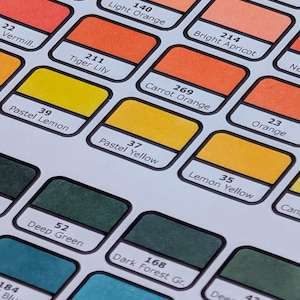 Puede incluir: Una carta de colores con una cuadrícula de muestras de color rectangulares y redondeadas. Cada muestra incluye un código numérico y un nombre descriptivo como Blushed Skin 257, Light Orange 140, Tiger Lily 211, Pastel Lemon 39, Deep Green 52 y Verona Blue 251.