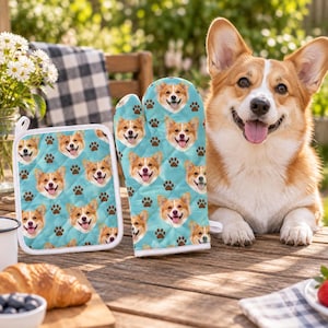 May include: A quilted oven mitt and a matching square pot holder, both featuring a repeating pattern of Corgi dog faces and brown paw prints on a light blue background, designed for kitchen use with white fabric trim edges.