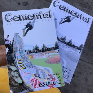 May include: Two copies of Cemental Skateboard Zine, issue #22, a special issue for the P-Stone Cup. The cover features a skateboarder in mid-air, performing a trick over a ramp.