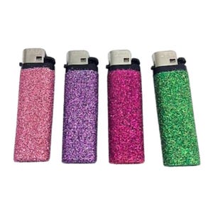 May include: Four lighters with glitter covers. The lighters are pink, purple, red, and green.