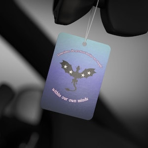 May include: A rectangular tag with a gradient blue and purple background, featuring a silhouette of a dragon with star accents. The tag includes the text: "Sometimes the greatest battles are fought within our own minds."