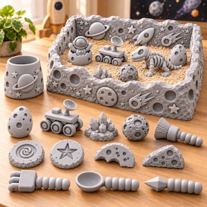 May include: A gray space-themed sensory bin set featuring a rectangular cratered tray filled with sand, a small cup, and various space-themed figurines including an astronaut, a rover, a dinosaur skeleton, planets, stars, and tools.