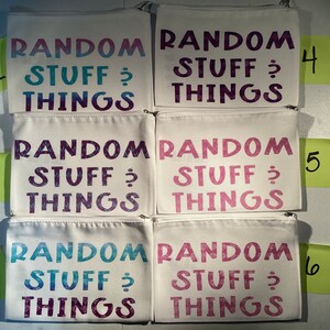 Può includere: Sei pochette bianche con cerniera con il testo "RANDOM STUFF & THINGS" in un degradé di rosa, blu e viola. Le pochette sono numerate da 1 a 6.