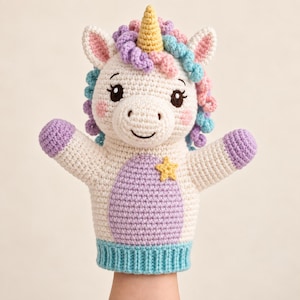 Könnte beinhalten: Eine gehäkelte Einhorn-Handpuppe mit cremefarbenem Körper, gelbem Horn und einer Mähne aus lockigem violettem, rosa und blauem Garn. Die Puppe hat einen hellvioletten Bauchfleck mit einem kleinen gelben Stern, rosa Wangen und einen hellblauen gerippten Saum.