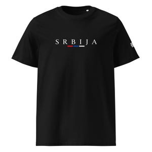 Puede incluir: Una camiseta negra de manga corta con el texto blanco SRBIJA centrado en el pecho. Debajo del texto hay una línea horizontal dividida en tres segmentos de colores rojo, azul y blanco. Un pequeño gráfico blanco es visible en la manga izquierda.