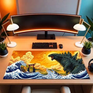 May include: A rectangular desk mat featuring a vibrant illustration of a large, dark green monster emerging from blue ocean waves. The background displays a bright yellow sun, orange clouds, and a traditional Japanese torii gate near the water.