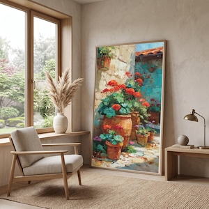Può includere: Un grande dipinto verticale incorniciato che raffigura una scena vivace di gerani rosso brillante piantati in vasi di terracotta contro un muro di pietra strutturato, con pennellate visibili e una ricca tavolozza di colori nei toni dell'arancione, del blu e del verde.