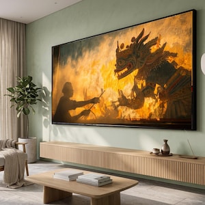 May include: A large rectangular wall-mounted television displaying a vibrant scene of a silhouette figure interacting with a fiery, ornate mythological creature. The screen is positioned above a long, light-toned wooden media console with vertical slats.