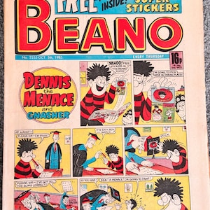 May include: A vintage copy of The Beano comic book, issue number 2255 from 5th October 1985. The cover features a colourful comic strip titled Dennis the Menace and Gnasher, showcasing the characters in a school setting with various speech bubbles.
