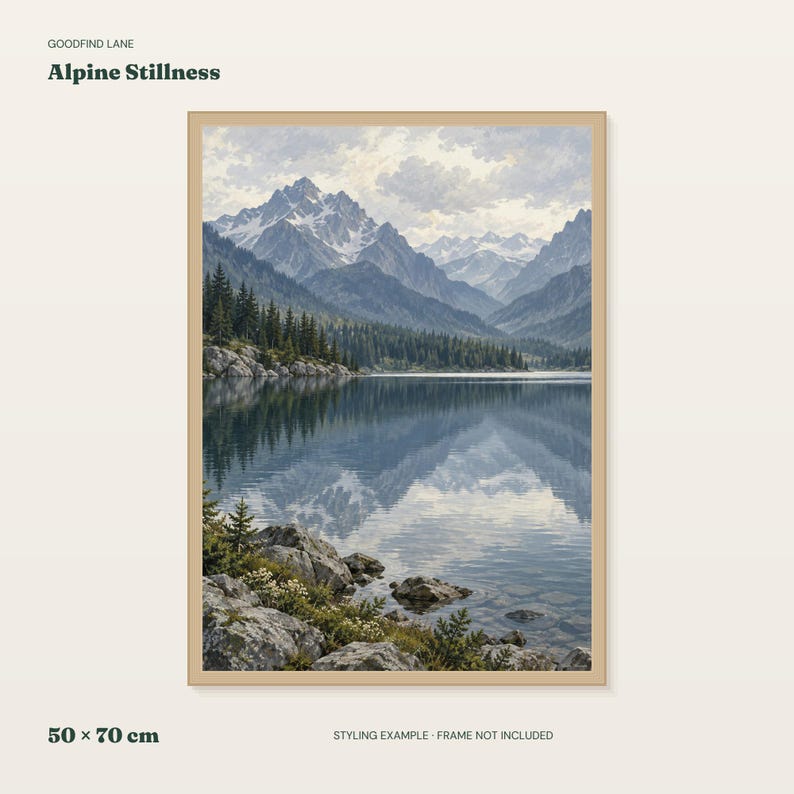 Puede incluir: Una impresi&oacute;n de arte mural enmarcada titulada Alpine Stillness que presenta un paisaje de monta&ntilde;as nevadas, un denso bosque de pinos y un lago tranquilo que refleja los picos. El primer plano muestra un terreno rocoso con peque&ntilde;as flores blancas.