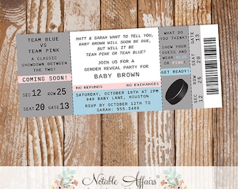 May include: A gender reveal party invitation in the form of a hockey ticket. The ticket is blue and gray with pink and white accents. It says "Team Blue vs Team Pink" and "Baby Brown" with the date and time of the party.
