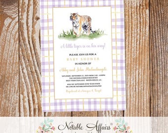 May include: Baby shower invitation featuring a tiger illustration. The design includes a purple and white gingham pattern, gold borders, and the text "A little tiger is on his way!" with event details.