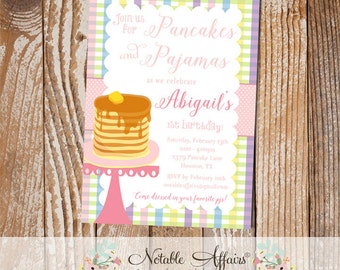 May include: A pink and white invitation with a checkered pattern. The invitation is for Abigail's 1st birthday party. The party is themed around pancakes and pajamas. The invitation includes the date, time, and location of the party. It also includes a request for guests to RSVP by a certain date. The invitation has a cartoon image of a stack of pancakes with syrup and a pat of butter on top.