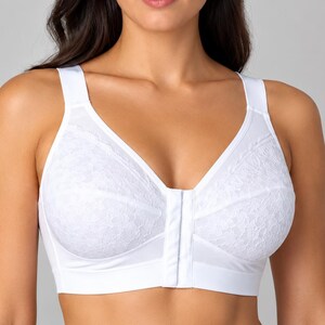 May include: A white front-closure bra featuring full-coverage cups with a delicate floral lace overlay on the upper sections, wide supportive shoulder straps, and a smooth, solid white fabric band along the bottom for secure fit.