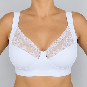 May include: A white bra featuring wide shoulder straps and a V-neckline. The upper portion of the cups is adorned with a delicate, semi-sheer floral lace overlay, while the lower cups and the band are constructed from a solid, opaque white fabric.