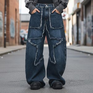 May include: Dark blue denim jeans featuring a wide-leg silhouette and a prominent star-shaped design on the front. The star pattern is outlined with frayed, raw-edge denim seams, creating a textured appearance. The jeans include a standard waistband.